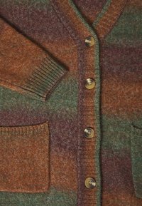 Ullkofta med V-ringning, strukturerad stickning i gröna, orange och vinröda nyanser, med fem knappar och två framfickor.