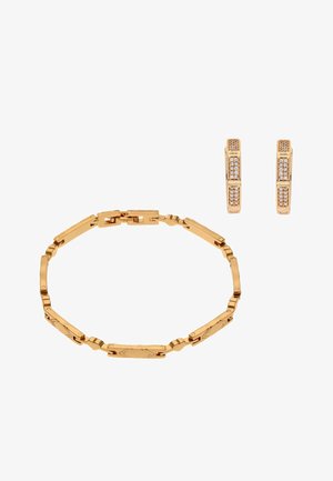 Arany láncszem karkötő geometriai mintákkal, hozzá illő arany karika fülbevalókkal, apró tiszta kövekkel díszítve.