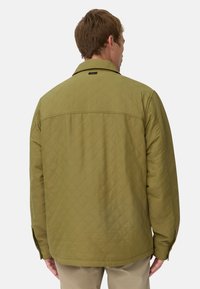 Gequilted olijfgroene jas met een kraag, lange mouwen en een rechte zoom. Kenmerkt zich door een ruitpatroon en zichtbare stiksels op de achterkant.