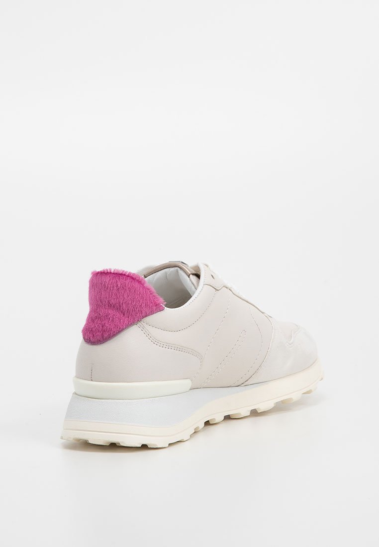 Sneaker bianco con suola spessa e linguetta posteriore pelosa di un vivace rosa, mostrato angolato sul retro su sfondo bianco semplice.