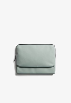 Housse d'ordinateur portable grise avec une finition lisse et mate, équipée d'une fermeture éclair noire et d'un logo de marque discret à l'avant. Forme rectangulaire avec des coins arrondis.
