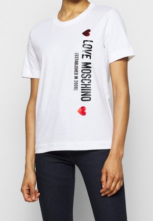 White cotton t-shirt with short sleeves. Features black "LOVE MOSCHINO" text and red hearts. Straight hem, relaxed fit. Minimalistic design.