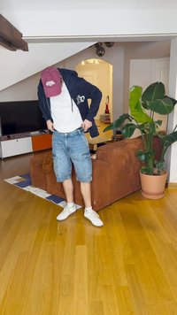 Calções de ganga com um tom de azul claro, apresentando bolsos cargo. Combinados com uma camisete branca e um hoodie azul marinho, completados com ténis brancos.