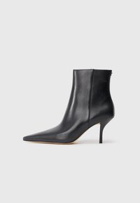 Must musta ankle kink, mille terava nina, saleda stilettokõrgusega konts ja sujuva viimistlusega. Tagaküljel on lukudetail.