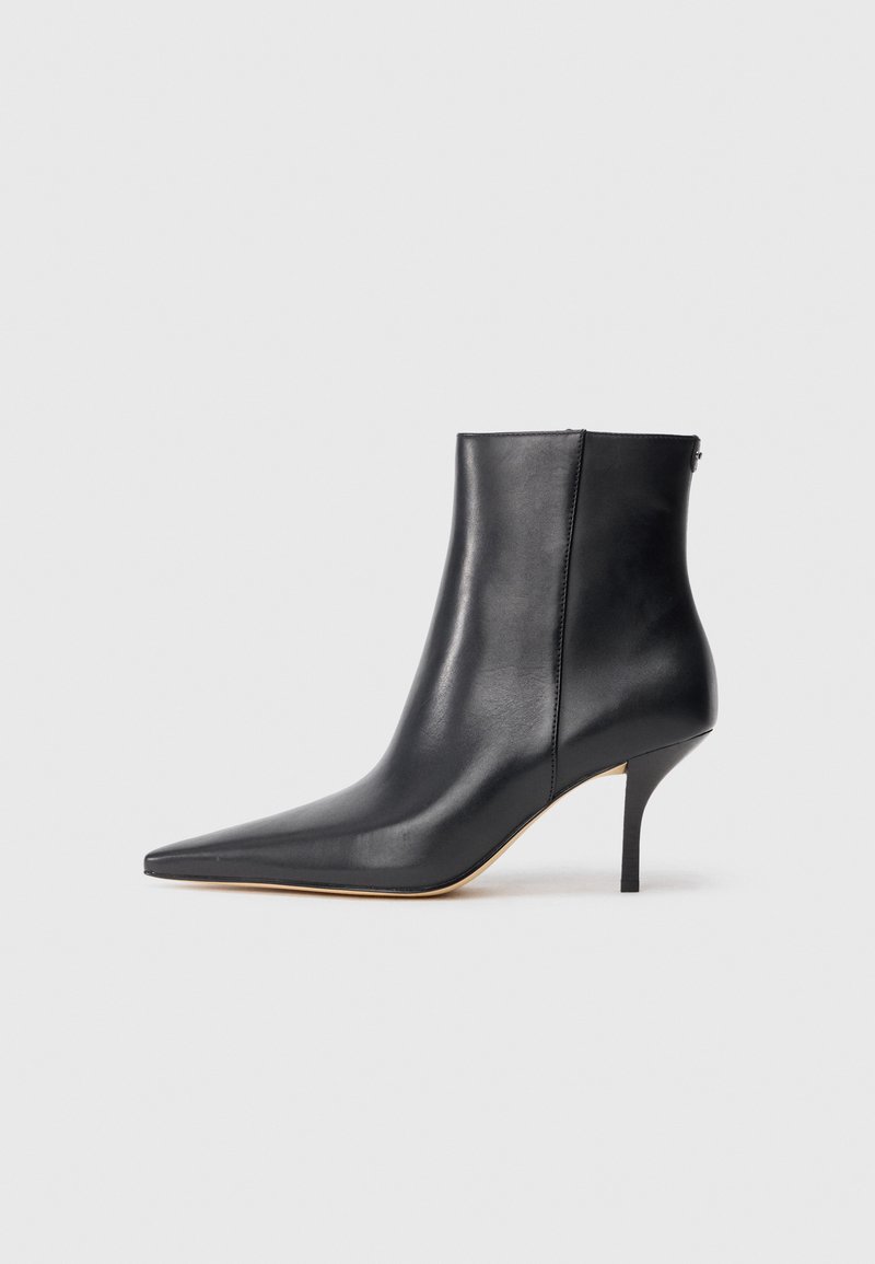 Must musta ankle kink, mille terava nina, saleda stilettokõrgusega konts ja sujuva viimistlusega. Tagaküljel on lukudetail.