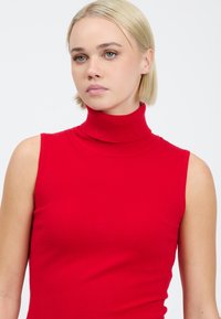 Rød ærmeløs turtleneck sweater, strikket materiale med ribbet hals, tætsiddende design, glat tekstur og minimalistisk stil.