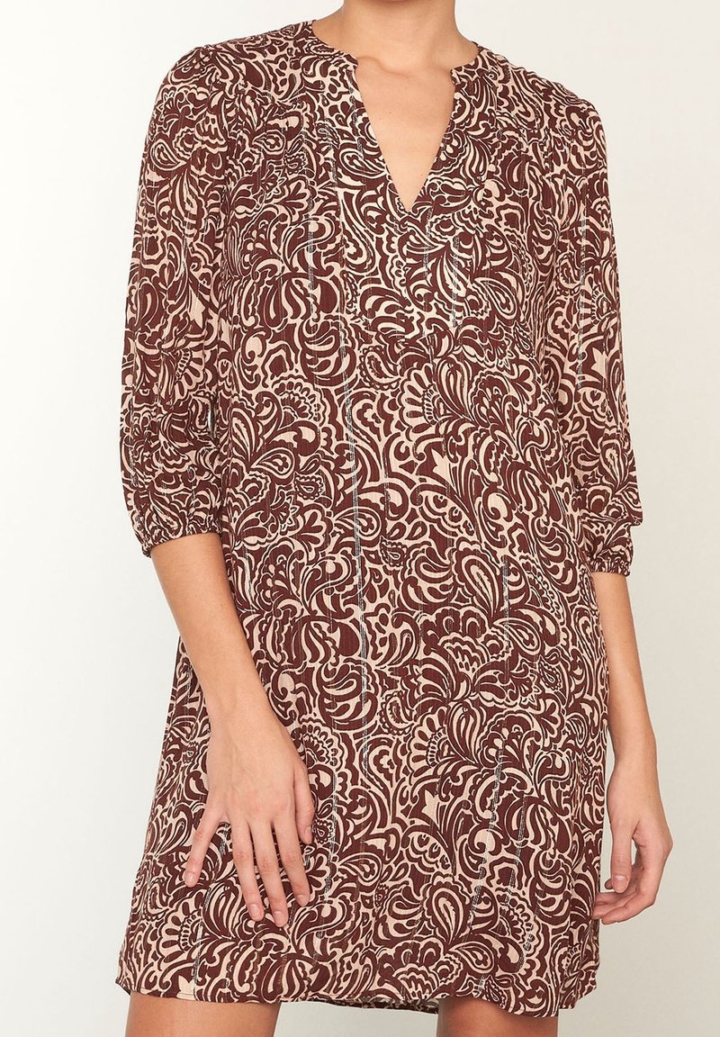Mörkröd och beige mönstrad klänning med V-ringning, trekvartsärmar och ett lätt tyg, som har intrikata snurrande mönster.