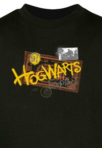 Schwarzes T-Shirt mit einem grafischen Motiv mit "HOGWARTS Express" in Gelb und Grau, einem Ticketdesign mit orangefarbenen Akzenten und einem verblassten Bild.