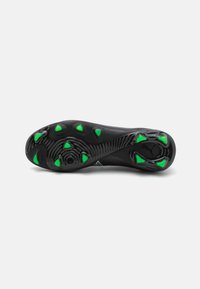 Black athletic shoe outsole featuring textured rubber with green triangular studs for traction. Curved design and gripping pattern throughout.