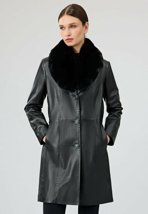 Schwarzer Lederjacke mit einem Kragen aus Kunstfell, Knopfverschluss und seitlichen Taschen. Mit gesteppten Details und einer schlanken, taillierten Passform.