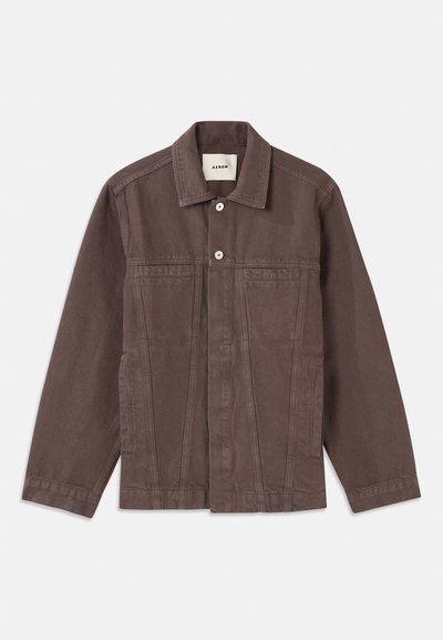 Rudas, sunkus švarkas su mygtukų užtrauktuku, krūtinės kišenėmis ir klasikiniu apykakle. Savybės: struktūriniai siūlai ir šoninės kišenės.