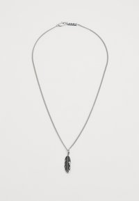 Collier en chaîne en argent avec un pendentif en forme de plume détaillée en noir et argent, et un fermoir avec une petite étiquette gravée.