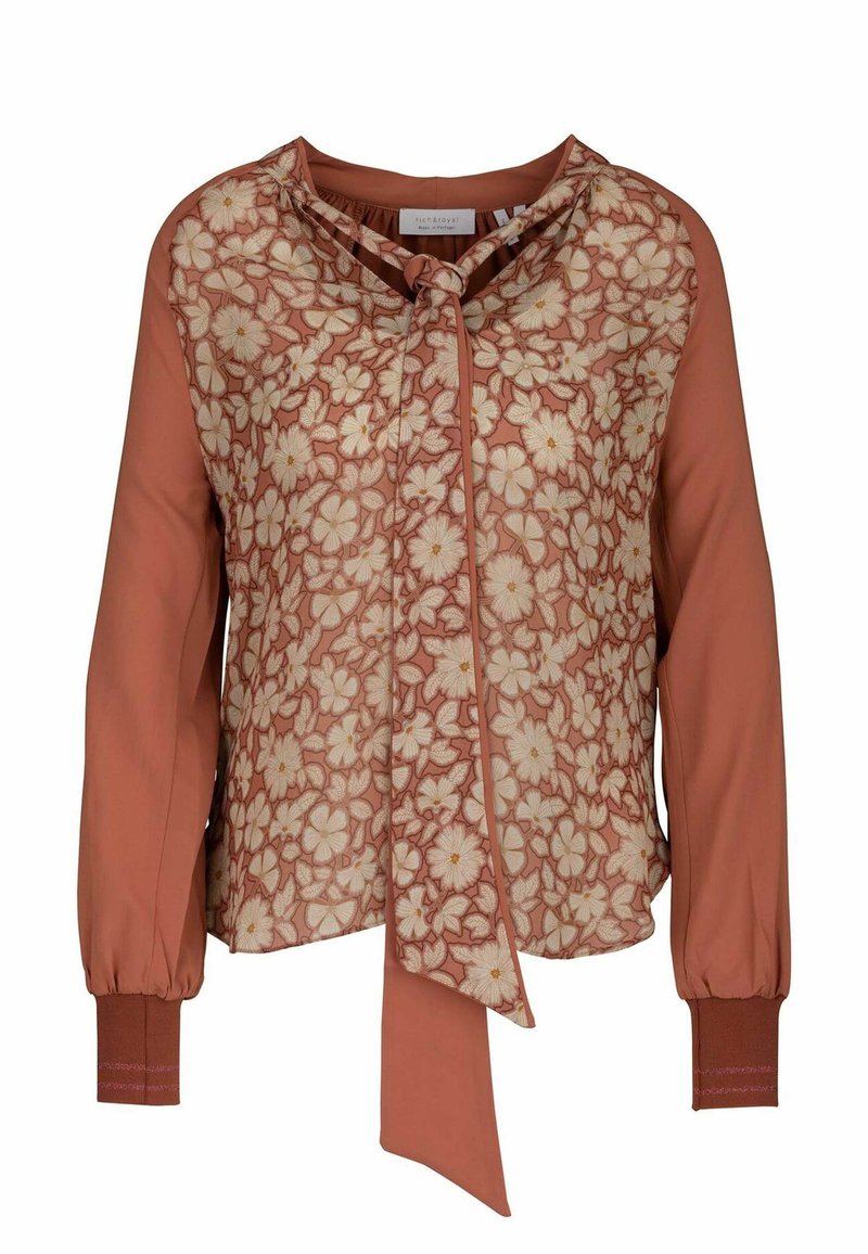 Bluse mit einem blumigen Muster in warmem Terrakotta, mit einem Bindekragen und langen Ärmeln mit gerippten Bündchen. Glatte Textur.