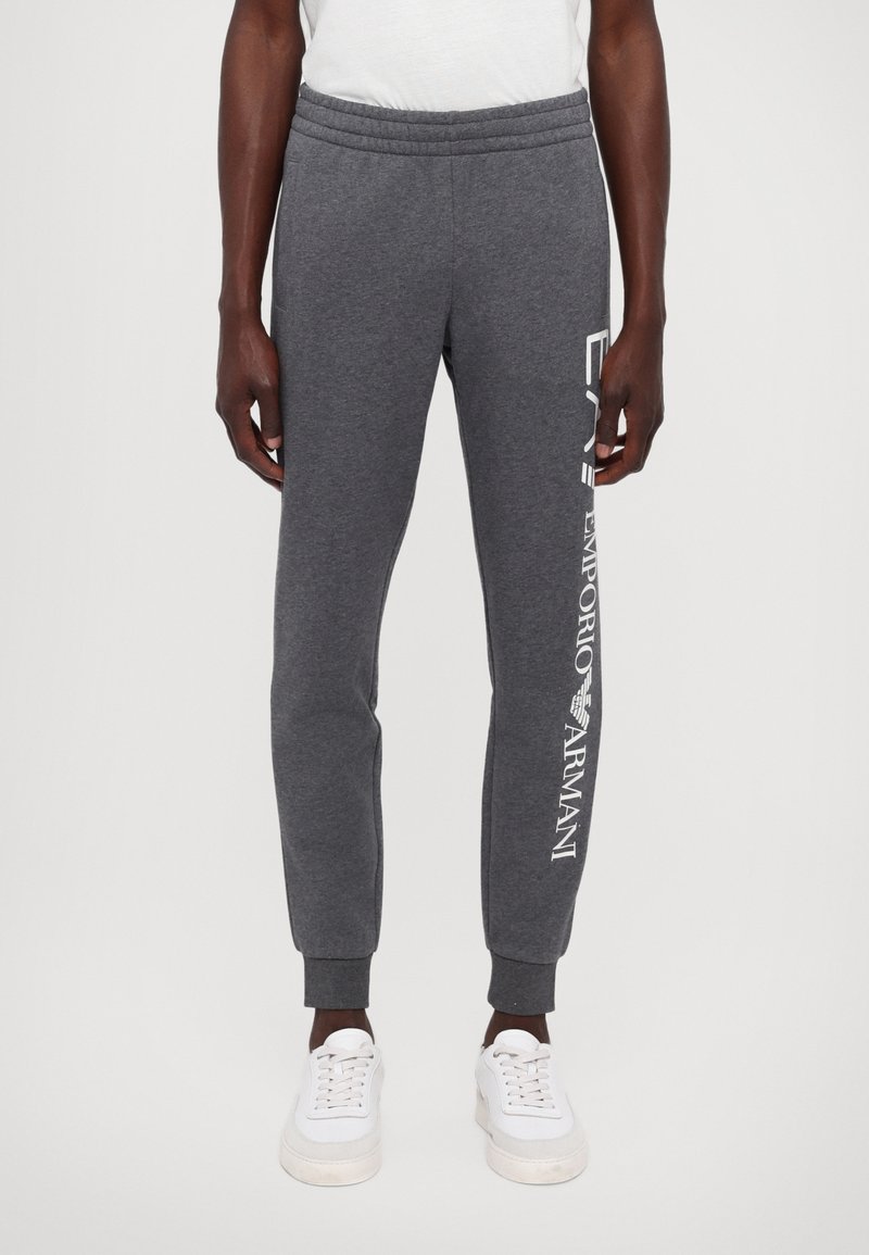 Szare spodnie dresowe wykonane z bawełnianej mieszanki, o dopasowanym kroju, z elastycznym pasem i białym nadrukiem logo na lewej nogawce.
