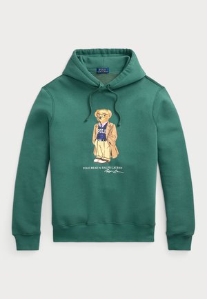 Zelena kapuca iz bombaža, z grafiko medveda v sproščenem oblačilu, z napisom "Polo Bear by Ralph Lauren" pod obliko.