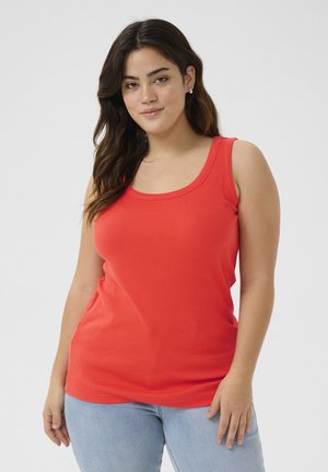 Top de tirantes rojo con canalé y escote redondeado, combinado con jeans ajustados de lavado claro.