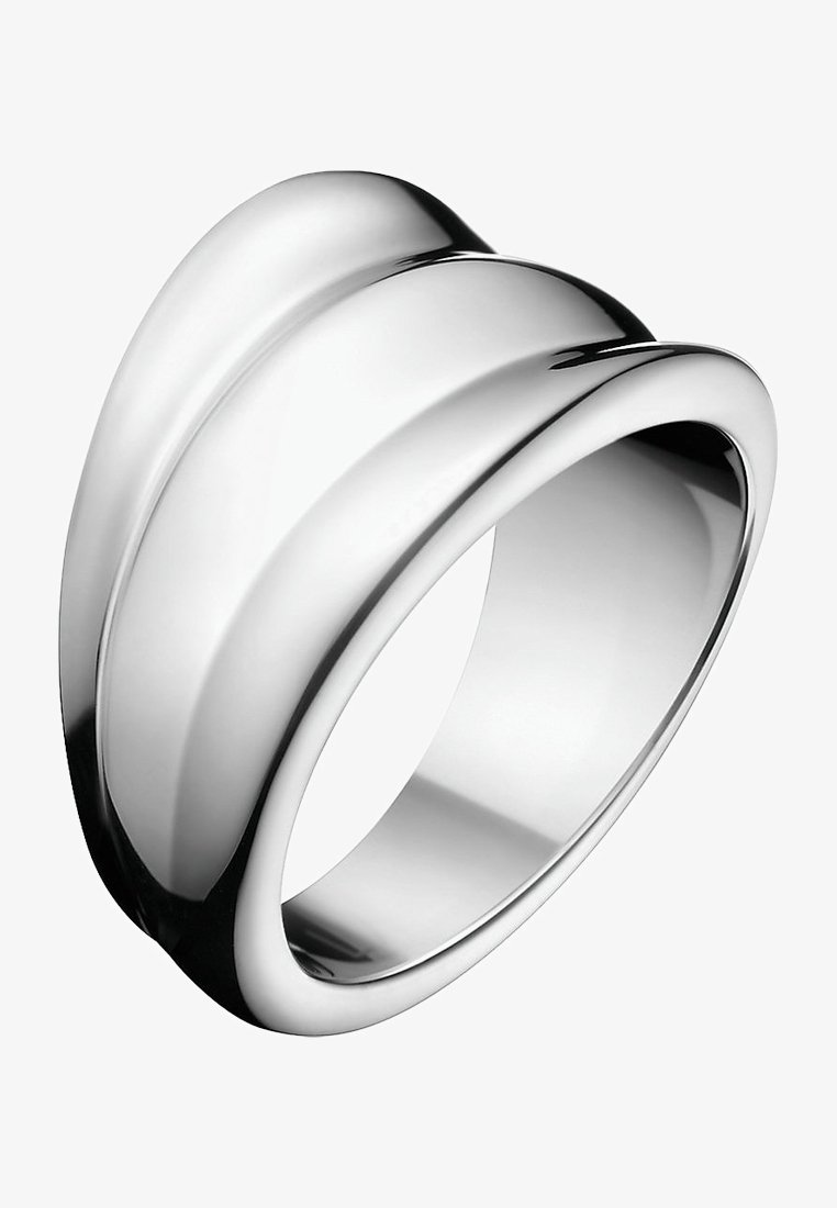 Large bague en argent avec une surface polie et lisse et une arête centrale surélevée, montrée sous un léger angle sur un fond blanc.