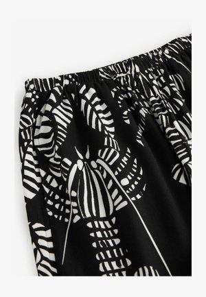 Zwarte stof met een witte botanische print. Voorzien van een elastische tailleband met een geraffineerde textuur. Ontworpen met een vloeiende en lichte stof.