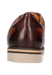 Zapato de vestir de cuero marrón con costuras oscuras, interior acolchado color beige, y suela en capas de color beige y marrón, visto desde la parte trasera.