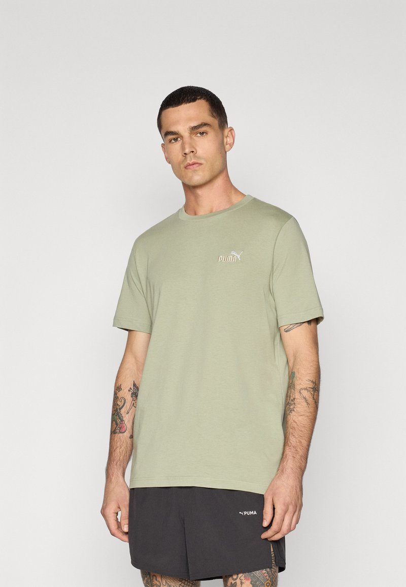 Lichtgroen katoenen T-shirt met een ronde halslijn en korte mouwen. Klein wit Puma-logo op de borst. Draag het met zwarte shorts.