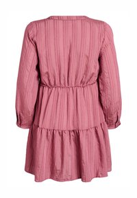 Vista trasera de un vestido rosa de manga larga con rayas verticales, cintura fruncida y dobladillo de falda escalonada.