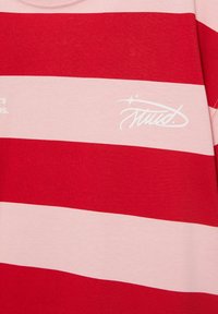 Rot und pink horizontal gestreifter Stoff mit weißem stilisiertem Text und Stern-Grafik auf dem pinken Streifen.