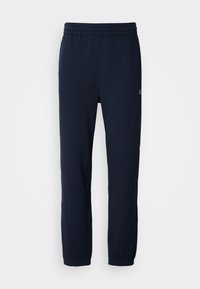 Pantalones de chándal navy con cinturilla elástica, piernas ajustadas y un pequeño detalle de logo en el lateral. Fabricados con una tela suave y ligera.