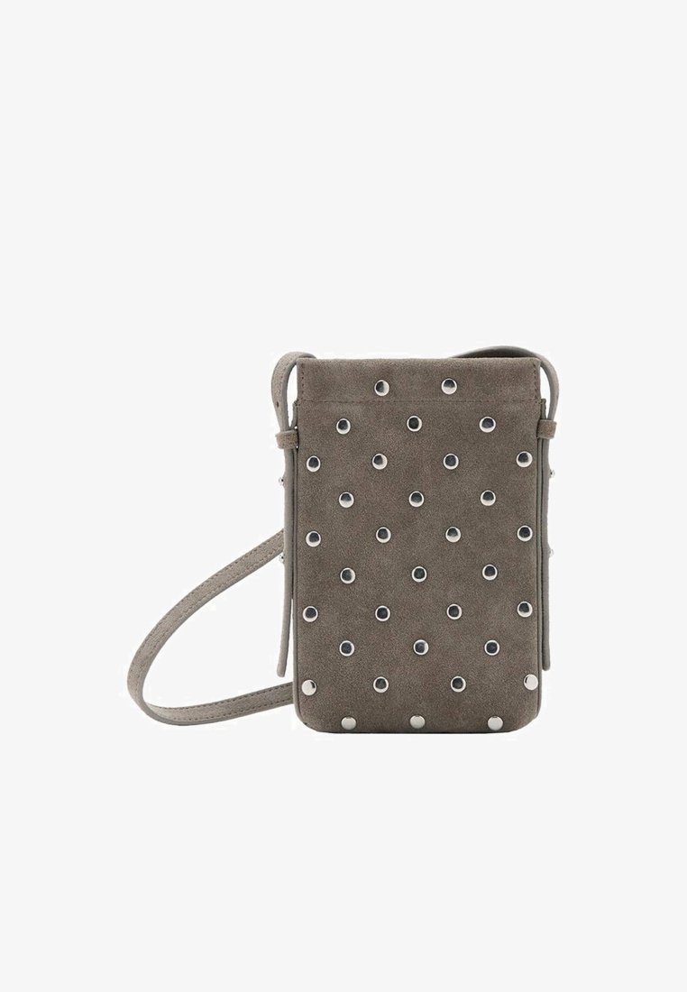 Torba čez ramo iz semiša v sivi barvi s srebrno strojno opremo. Spredaj ima okrogle zakovice in dolg nastavljiv pas. Pravokotna oblika.