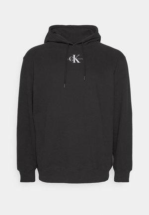 Sort hættetrøje lavet af blødt stof, med et hvidt logo foran. Den har en hætte med snor og ribbede manchetter og kant.