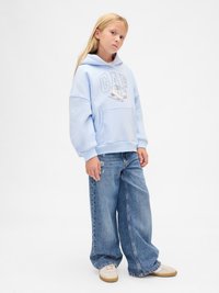 Light blue hoodie with "GAP" logo and graphic, large front pocket, paired with wide-leg distressed blue jeans and beige sneakers.