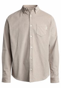 Camisa de pana color beige claro con mangas largas, cuello abotonado, bolsillo frontal y botones blancos. Diseño sencillo con tejido texturizado.