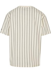 Kortærmet, cremet T-shirt med lodrette sorte striber, rund halsudskæring, løs pasform og blød tekstur. Ingen bemærkelsesværdig hardware eller accenter.