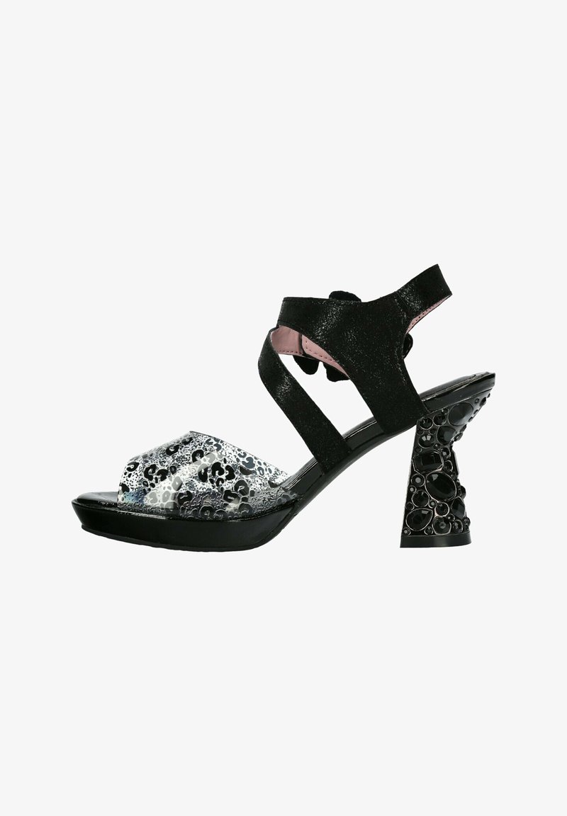 Sandale noire à talon haut avec talon rond texturé, bride de cheville noire et bride avant transparente avec un motif léopard.