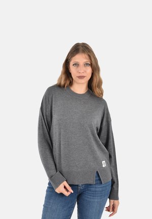 Maglione grigio oversize con maniche lunghe, polsini a coste e spacchi laterali, realizzato in materiale morbido, con un piccolo etichetta di tessuto sull'orlo.