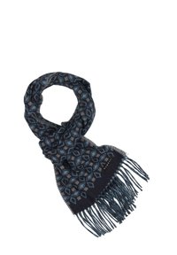 Écharpe en tricot avec un motif géométrique en bleu foncé et bleu clair, avec des extrémités frangées et une étiquette de marque subtile. Texture douce.