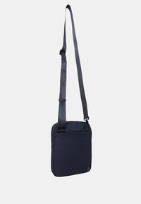 Borsa a tracolla blu navy con tessuto testurizzato, tracolla regolabile e tasca anteriore con zip per ulteriore spazio di archiviazione.