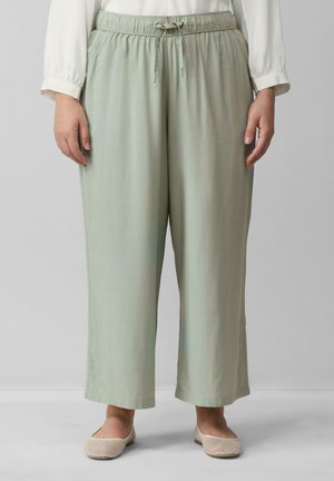 Pantalons légers en vert doux, décontractés, avec une taille élastique et un cordon de serrage, fabriqués en tissu doux. Un devant plat et des jambes larges complètent le design.