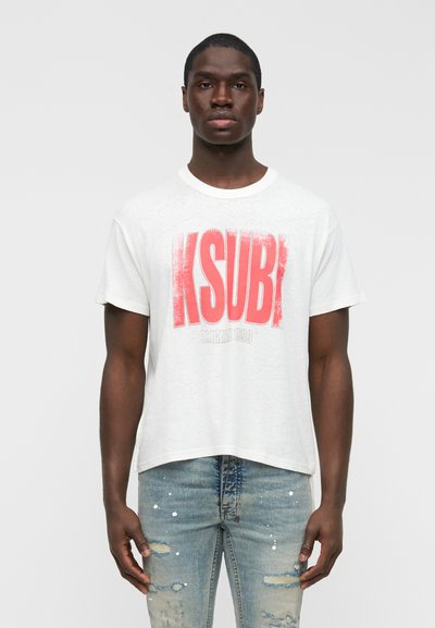 T-shirt blanc à manches courtes avec un graphisme rouge vif "KSUBI" sur le devant. Coupe ample avec un col rond et un ourlet légèrement raccourci.