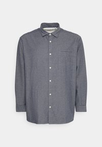 Camicia da uomo eletta in blu navy con strisce verticali bianche. Dotata di colletto, maniche lunghe e una singola tasca sul petto. Texture liscia.