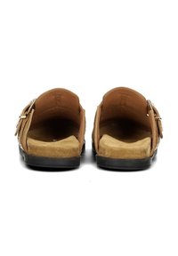 Sandali slip-on in suede marrone con una soletta testurizzata e una suola in gomma nera. Presentano un hardware in tonalità argento sul lato.