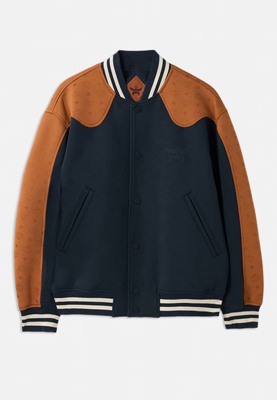 Navy blue varsity jacket with brown leather sleeves, striped neckline, textured shoulder panels, and front snap closures. Features side pockets.