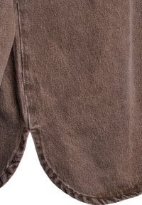 Hnědá látka s jemnou texturou, zaobleným lemem a prošívanými okraji. Materiál vypadá odolně a vykazuje jemný vzor tkaní.