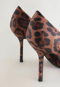 Et par brune og sorte leopardprint højhælede sko med spidse tæer og slanke stiletto hæle på en lys baggrund.