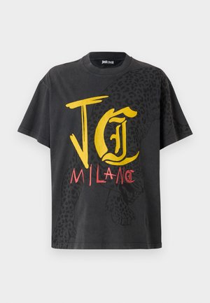 Svart t-skjorte med korte ermer som har gul og rød grafisk tekst "JG MILAN" og et leopardmønster på den ene siden. Laget av bomull.