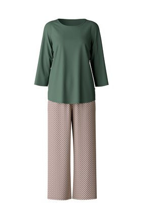 Grünes Langarmoberteil aus glattem Stoff, kombiniert mit weiten Hosen mit einem geometrischen Muster in Pink und Creme.