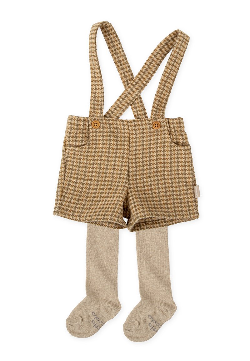 Peto corto marrón de houndstooth con tirantes cruzados, con botones de madera y combinado con medias de punto beige. Textura suave en todo su recorrido.