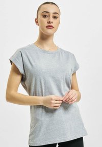 T-shirt grigio a maniche corte realizzato in tessuto morbido, con una vestibilità comoda e maniche arrotolate, caratterizzato da una texture liscia e un design minimale.