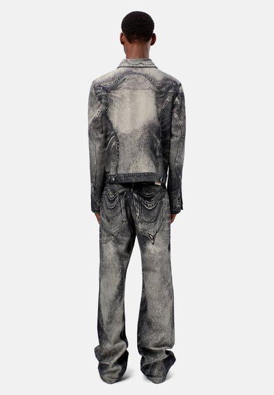 Giacca e pantaloni in denim in una tonalità di grigio e nero sbiadita, con una texture consumata e dettagli di cucitura classici.