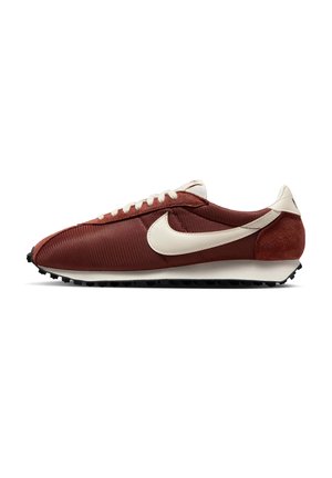Red and white athletic shoe with a textured fabric upper, suede accents, and a black rubber sole. Features a prominent side logo and lace-up closure.