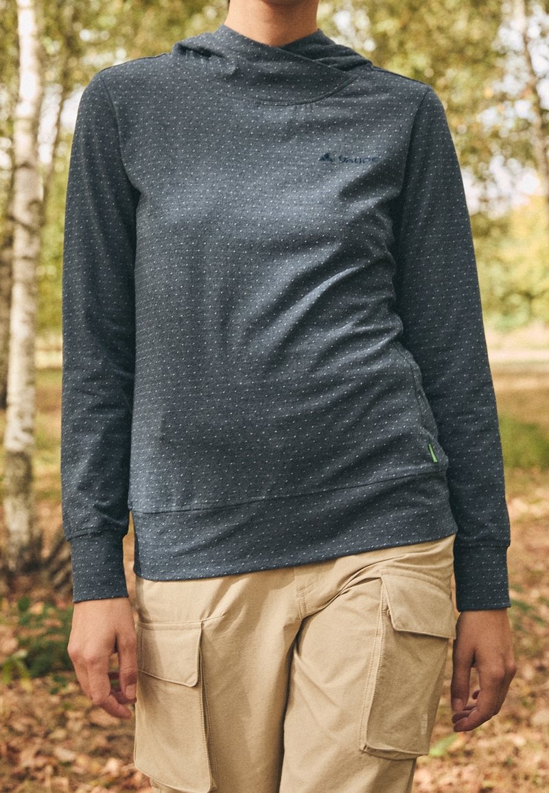 Sudadera azul marino con un patrón texturizado, mangas largas y un bolsillo canguro. Presenta un pequeño logo y un acento verde en el dobladillo.